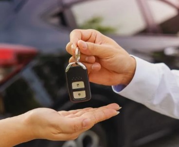 Locksmith providing new car key to customer